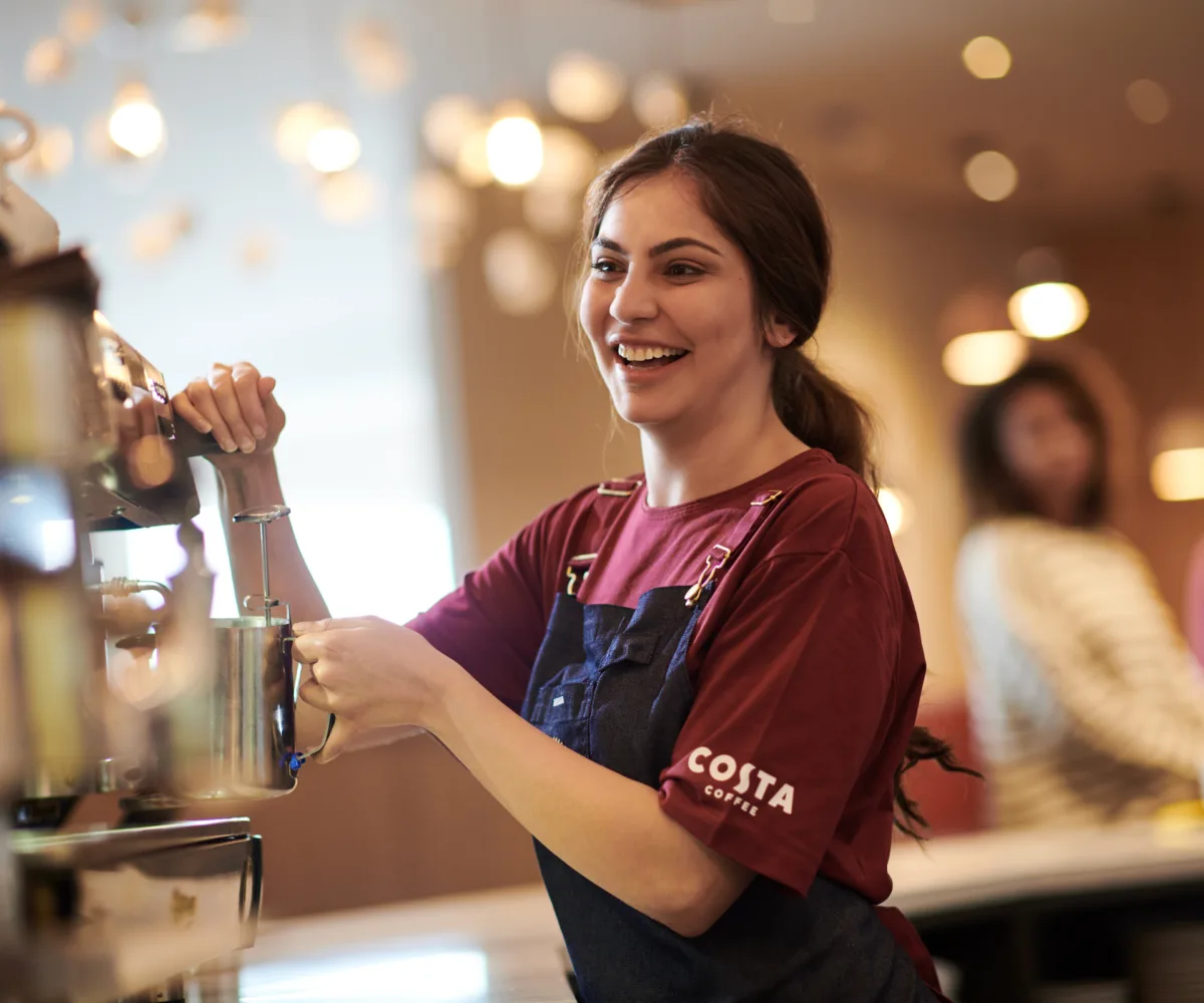 Costa Staff member frothing Milk